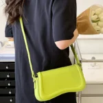 Sac à main Lina en similicuir vert avec bandoulière porté par une femme, disponible chez Boutique Izamel.