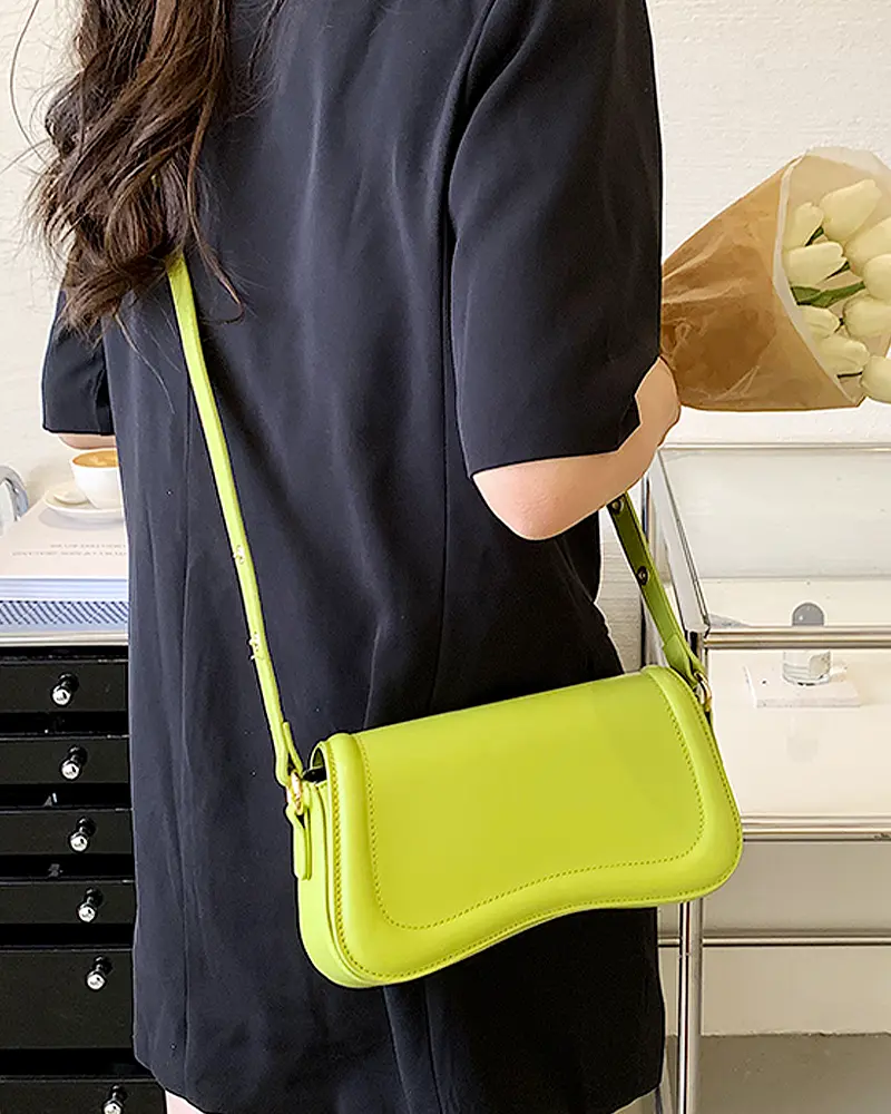 Sac à main Lina en similicuir vert avec bandoulière porté par une femme, disponible chez Boutique Izamel.