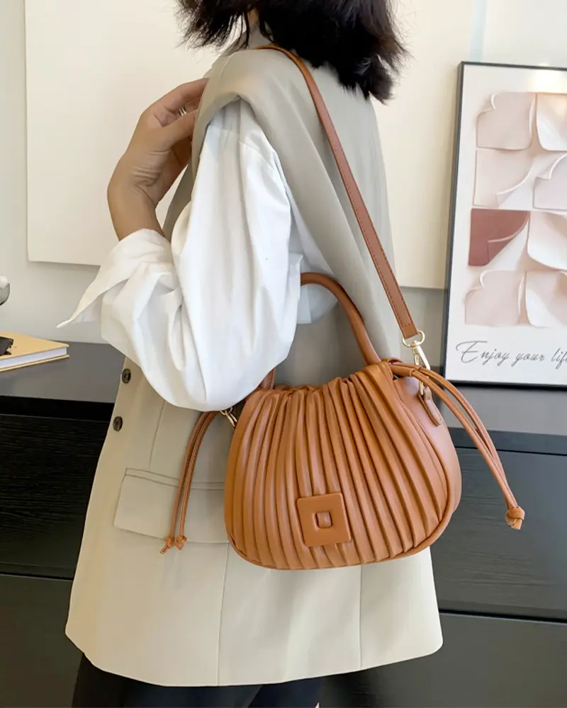 Sac à main Mia plissé caramel porté à l'épaule par une femme, disponible chez Boutique Izamel.