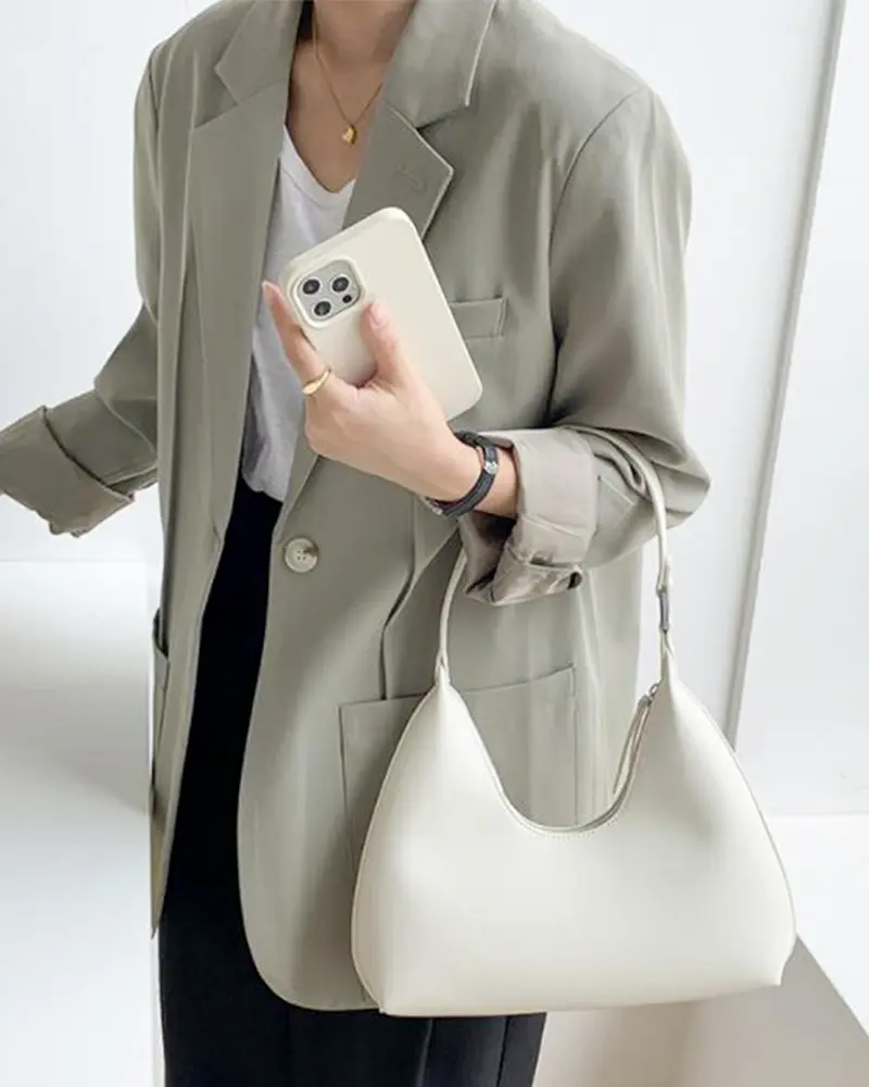 Sac à main Samia en similicuir blanc porté au bras par une femme, disponible chez Boutique Izamel.