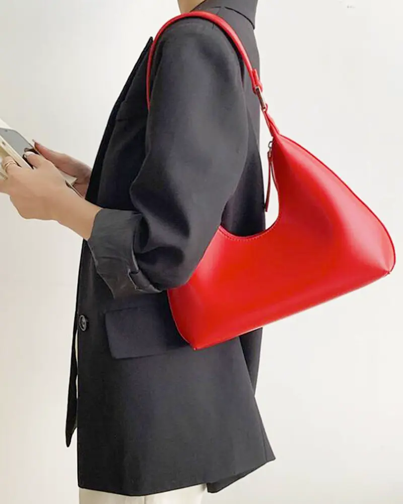 Sac à main Samia en similicuir rouge porté à l'épaule par une femme, disponible chez Boutique Izamel.